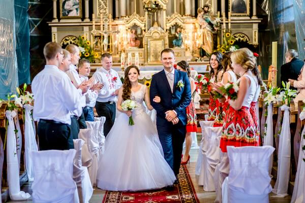 Elegancka moment wymiany obrączek w plenerze z altaną